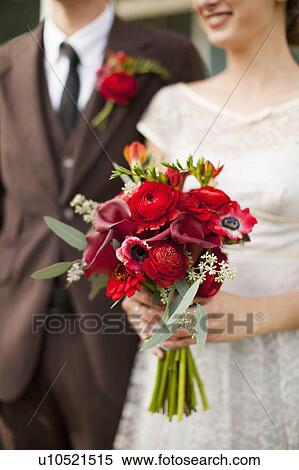 Mid section of wedding couple with bouquet in focus View Large Photo Image Stock Photography - Mid section of wedding couple with bouquet in focus. Fotosearch