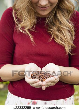 Stock Photo - Mid-section of woman holding pine nuts. Fotosearch