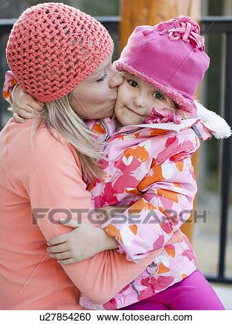 Stock Image - Mother kissing daughter (4-5) outdoors. Fotosearch