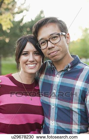 Stock Image - Portrait of couple in park. Fotosearch