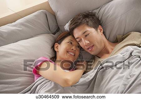 Portrait of couple lying in bed View Large Photo Image Stock Photo - Portrait of couple lying in bed. Fotosearch