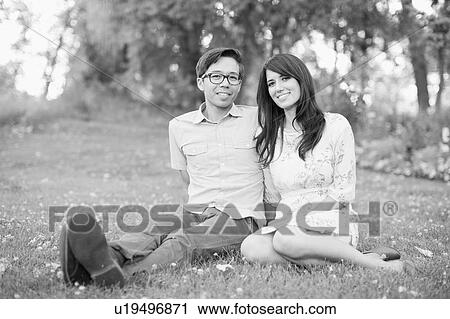 Portrait of couple relaxing in park View Large Photo Image Stock Image - Portrait of couple relaxing in park. Fotosearch