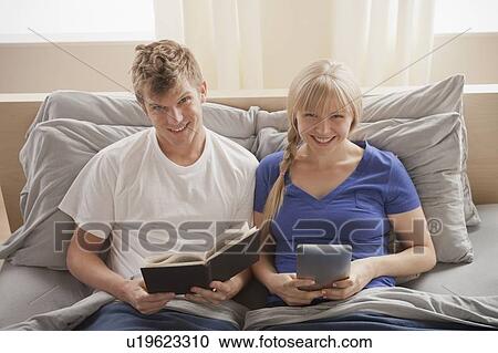 Portrait of couple sitting in bed reading View Large Photo Image Stock Image - Portrait of couple sitting in bed reading. Fotosearch