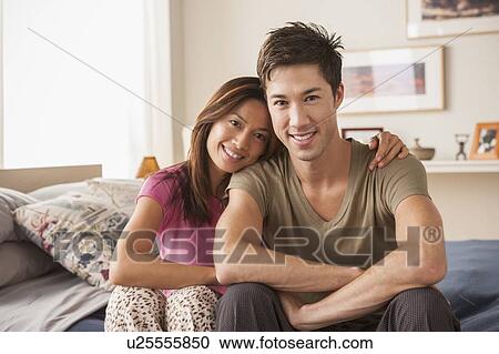 Portrait of couple sitting on bed View Large Photo Image Stock Image - Portrait of couple sitting on bed. Fotosearch