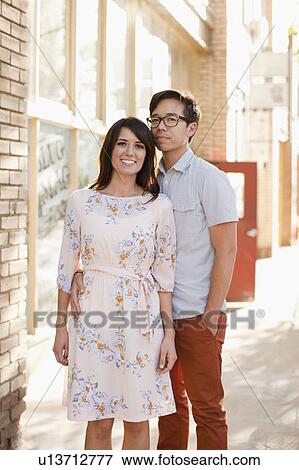 Portrait of couple standing on sidewalk View Large Photo Image Stock Photo - Portrait of couple standing on sidewalk. Fotosearch
