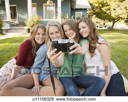 Stock Photo - Portrait of four friends taking picture of themselves. Fotosearch