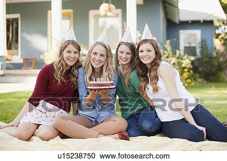 Stock Image - Portrait of four friends with birthday cake. Fotosearch