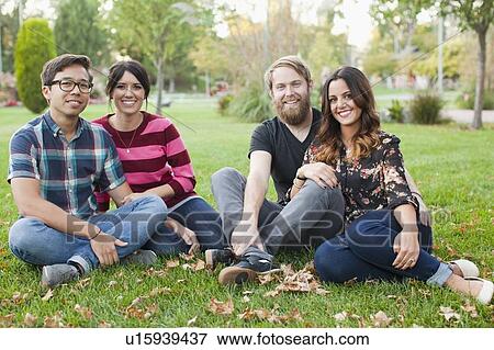 Portrait of group of friends sitting on grass View Large Photo Image Stock Photo - Portrait of group of friends sitting on grass. Fotosearch