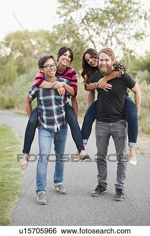 Portrait of group of friends piggy-backing View Large Photo Image Stock Photograph - Portrait of group of friends piggy-backing. Fotosearch