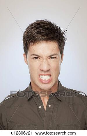 Stock Image - Portrait of man clenching teeth. Fotosearch