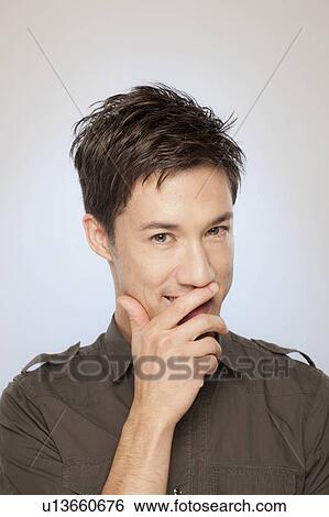 Portrait of man covering his mouth View Large Photo Image Stock Photograph - Portrait of man covering his mouth. Fotosearch
