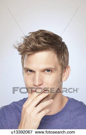 Portrait of man covering his mouth with hand View Large Photo Image Stock Photo - Portrait of man covering his mouth with hand. Fotosearch