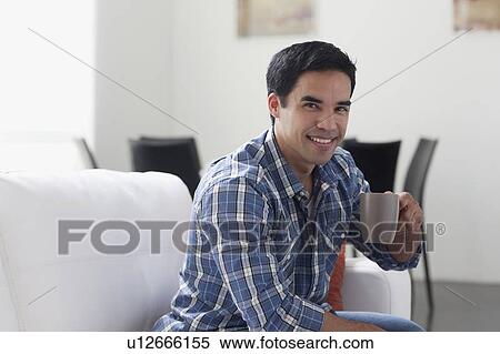 Portrait of man drinking coffee in living room View Large Photo Image Stock Photography - Portrait of man drinking coffee in living room. Fotosearch