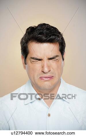 Stock Image - Portrait of man frowning with closed eyes. Fotosearch