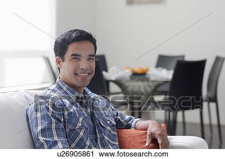 Portrait of man sitting in living room View Large Photo Image Stock Image - Portrait of man sitting in living room. Fotosearch