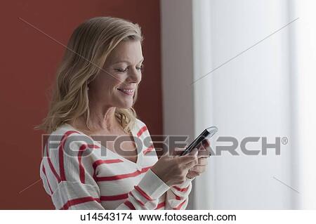 Picture - Portrait of mature woman texting. Fotosearch