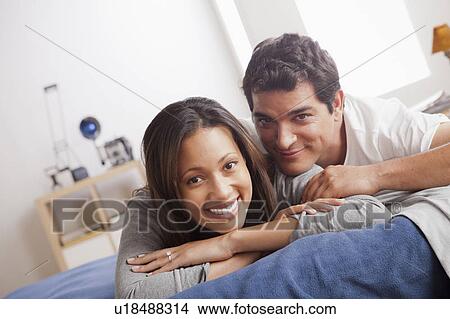 Portrait of mid adult couple laying on bed View Large Photo Image Picture - Portrait of mid adult couple laying on bed. Fotosearch