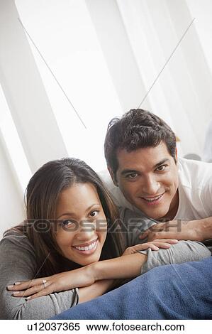Portrait of mid adult couple laying on bed View Large Photo Image Stock Photography - Portrait of mid adult couple laying on bed. Fotosearch