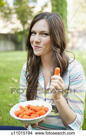 Portrait of mid adult woman eating carrots View Large Photo Image Picture - Portrait of mid adult woman eating carrots. Fotosearch