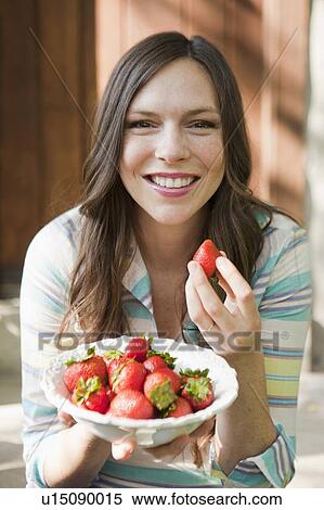 Portrait of mid adult woman eating strawberries View Large Photo Image Stock Photography - Portrait of mid adult woman eating strawberries. Fotosearch
