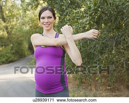 Portrait of pregnant mid adult woman in sport clothing stretching arms View Large Photo Image Stock Image - Portrait of pregnant mid adult woman in sport clothing stretching arms. Fotosearch