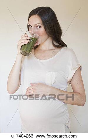 Portrait of pregnant mid adult woman drinking green juice View Large Photo Image Stock Image - Portrait of pregnant mid adult woman drinking green juice. Fotosearch
