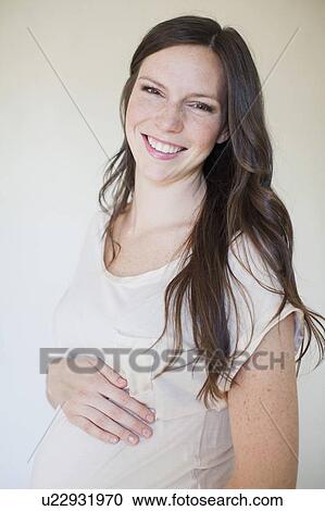 Stock Image - Portrait of pregnant mid adult woman. Fotosearch