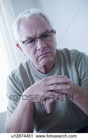 Stock Image - Portrait of sad senior man wearing spectacles. Fotosearch