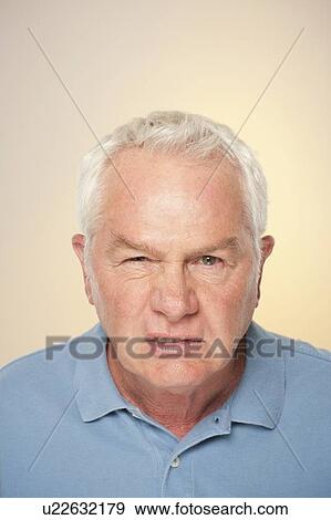 Stock Photo - Portrait of senior man pulling funny face. Fotosearch