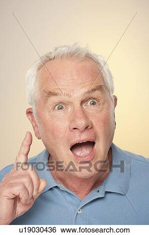 Stock Photograph - Portrait of senior man pulling funny face. Fotosearch