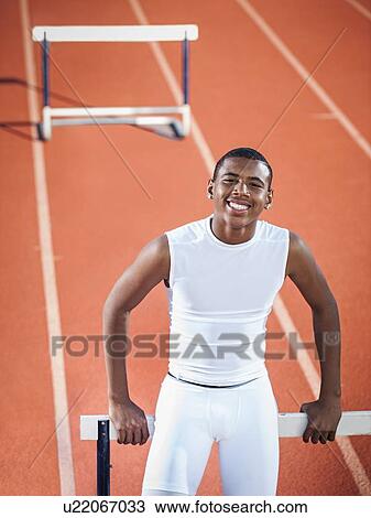 Portrait of smiling boy (12-13) leaning on hurdle on running track View Large Photo Image Stock Image - Portrait of smiling boy (12-13) leaning on hurdle on running track. Fotosearch