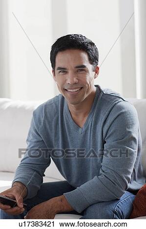 Portrait of smiling mid adult man sitting on sofa View Large Photo Image Stock Image - Portrait of smiling mid adult man sitting on sofa. Fotosearch