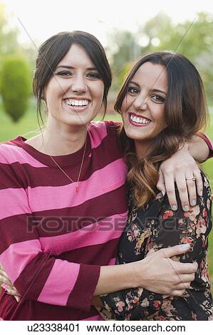 Portrait of two young women embracing View Large Photo Image Stock Image - Portrait of two young women embracing. Fotosearch