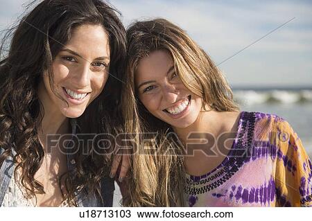 Stock Image - Portrait of two young women on beach. Fotosearch