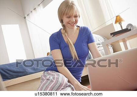 Portrait of woman sitting on floor using laptop View Large Photo Image Stock Image - Portrait of woman sitting on floor using laptop. Fotosearch