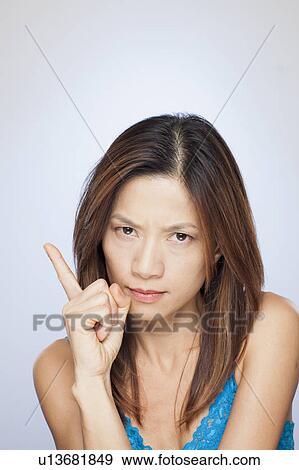 Portrait of woman with raised finger View Large Photo Image Stock Photo - Portrait of woman with raised finger. Fotosearch