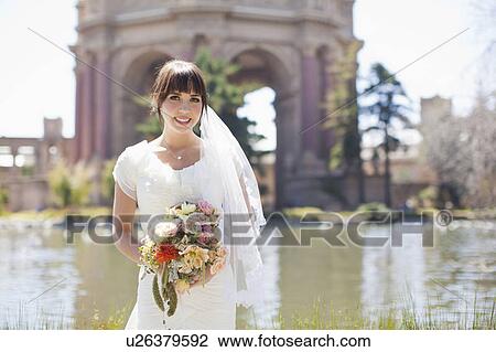Stock Image - Portrait of young bride in park. Fotosearch