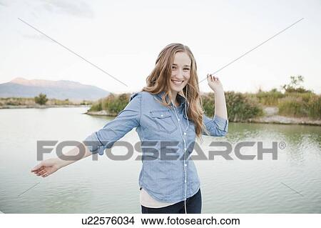 Picture - Portrait of young woman dancing player by lake. Fotosearch