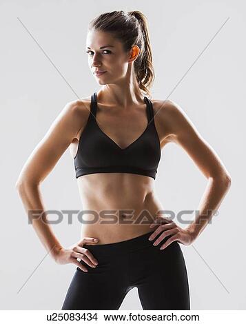 Picture - Portrait of young woman exercising, studio shot. Fotosearch