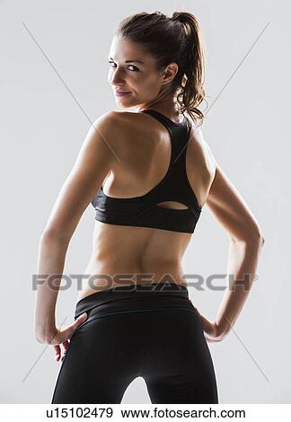 Portrait of young woman exercising, studio shot View Large Photo Image Stock Photo - Portrait of young woman exercising, studio shot. Fotosearch