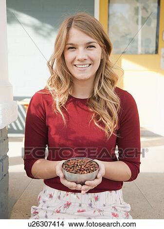 Portrait of young woman holding bowl with pine nuts View Large Photo Image Picture - Portrait of young woman holding bowl with pine nuts. Fotosearch