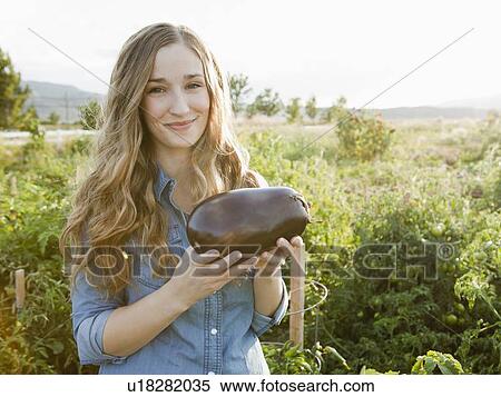 Portrait of young woman holding eggplant View Large Photo Image Stock Photography - Portrait of young woman holding eggplant. Fotosearch