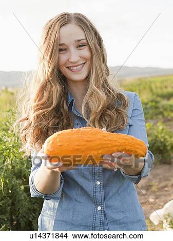 Portrait of young woman holding squash View Large Photo Image Picture - Portrait of young woman holding squash. Fotosearch