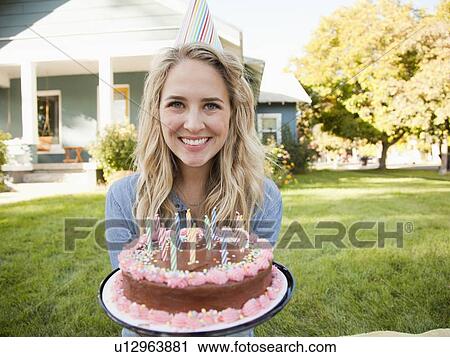 Portrait of young woman holding birthday cake View Large Photo Image Stock Image - Portrait of young woman holding birthday cake. Fotosearch