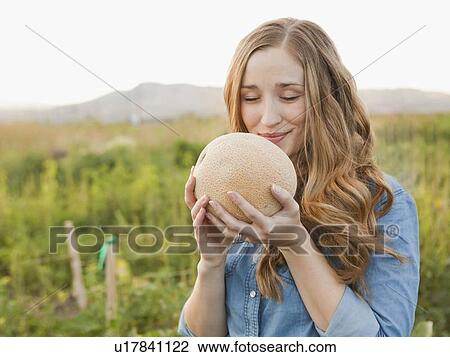 Portrait of young woman holding cantaloupe View Large Photo Image Stock Image - Portrait of young woman holding cantaloupe. Fotosearch