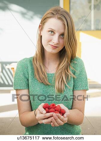 Portrait of young woman holding raspberries View Large Photo Image Stock Photo - Portrait of young woman holding raspberries. Fotosearch