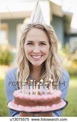 Portrait of young woman holding birthday cake View Large Photo Image Stock Photography - Portrait of young woman holding birthday cake. Fotosearch