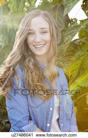 Stock Image - Portrait of young woman in garden. Fotosearch