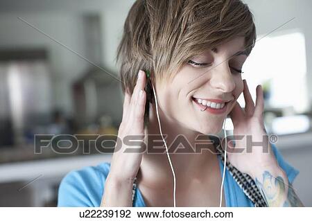 Portrait of young woman listening music View Large Photo Image Stock Image - Portrait of young woman listening music. Fotosearch
