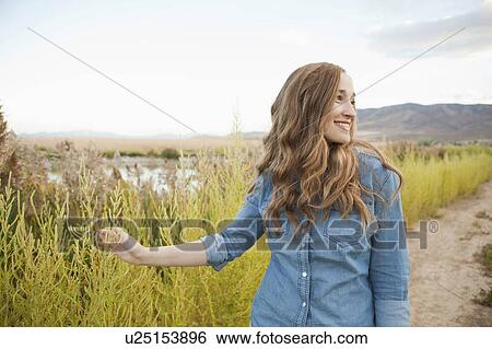 Portrait of young woman on dirt road View Large Photo Image Stock Photograph - Portrait of young woman on dirt road. Fotosearch